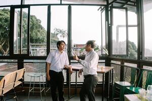 Two Southeast Asian men engaging in an enthusiastic conversation photo