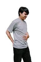 Southeast Asian man with a tense expression, visibly uncomfortable as he holds his stomach. photo