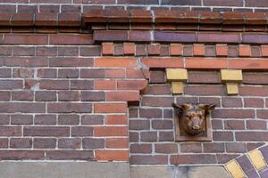 Brick facade with dentils and ox head photo