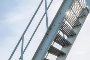 steel staircase with steps made of perforated sheet metal against the light photo