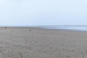 sandy beach in ouddorp, the netherlands, in bad cloudy autumn weather photo