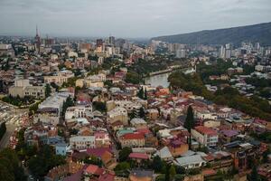 A stunning aerial view of Tbilisis vibrant city at dusk, blending historic and modern architecture photo
