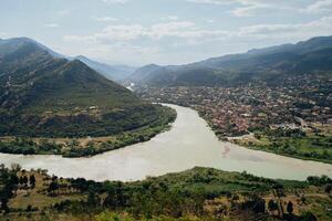 Spectacular view of the confluence of two rivers surrounded by mountains in a vibrant valley during the day photo