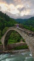 Senyuva bridge in Rize Turkey. Stone bridge on the Firtina River and people timelapse vertical . video