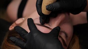 ampliado Visão do uma mulher sobrancelha microblading. permanente sobrancelha inventar, realizando sobrancelha tatuagem pmu video