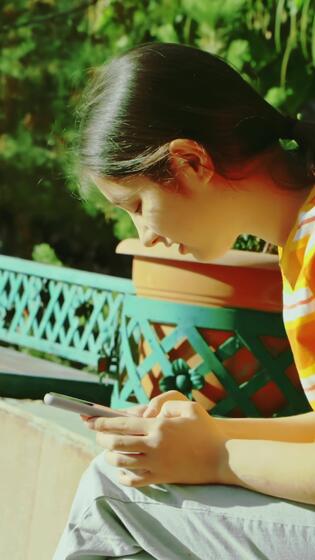 Adolescente niña utilizando teléfono y chateando en el parque. alto calidad 4k imágenes 51034709 Vídeo de stock en Vecteezy->