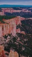 Splendid scenic view of Bryce Canyon. Endless mountainous territory overgrown with pine trees. Aerial perspective. Vertical video