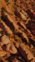 Descending over the rocks diverse in size and shape. Arches canyon in Utah, USA on sunny daytime from top view. Vertical video