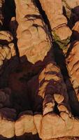 Group of rock formations with rounded tops from aerial erosion. Sunlit canyons of Arches National Park from top view. Vertical video