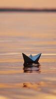 Paper ships on water surface at sunset. One origami boat floating in the river and another one joins to it. Vertical video