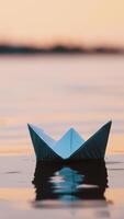 Nice paper boat on evening water surface. One blue origami ship sailing in the river calmly with its reflection outdoors. Vertical video