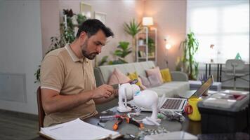 Creative man assembling a gadget in a cozy home workspace video