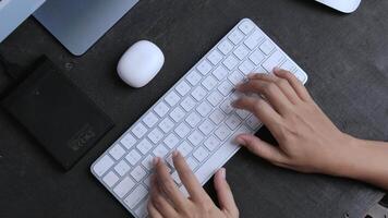 a woman is studying online in front of a computer with her hands typing on the keyboard video
