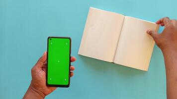 A modern smartphone alongside an open book, both placed on a vibrant and colorful background video