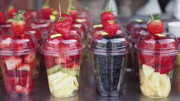 pineapple, kiwi and Strawberries in. plastic container selling at shop video
