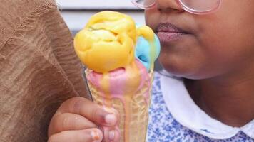 A Happy Child is Joyfully Enjoying a Colorful Ice Cream Cone on a Beautiful Warm Day Outside video