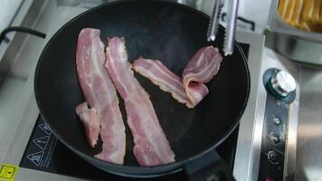 fried bacon slice of pork bacon is prepared in its own fat. Layer of meat and lard. Close up in the kitchen. video