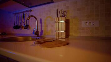 Home cooking zoom in view of small bamboo cutting board and chef knife on the counter top. video