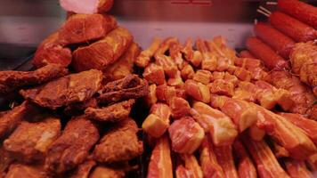 Wide range of smoked beef and lamb along with different types of salami in show window. video
