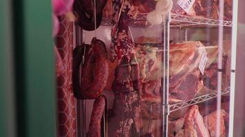 Slices of dried beef meat along with types of sausages in dry ading cabinet. video