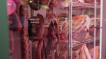 Slices of dried or smoked beef meat along with types of sausages in dry ading cabinet. video