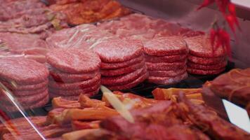 Burger cutlets on display in butchers shop vitrine made of beef meat. video