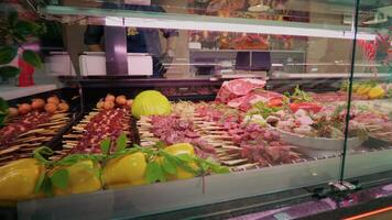 Zoom in chops of beef meat on skewers layout in the store. video