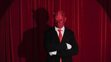 Businessman with red devil mask making gestures video