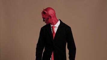 Red devil businessman making gestures on solid background video