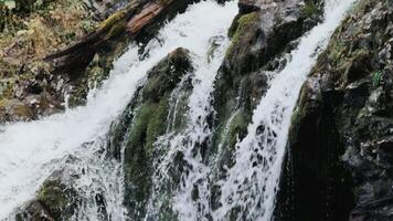Stormy waterfall rushing between the rocks close up. Water pouring down the gorge, seething and foaming stream, a stunning and majestic piece of nature video