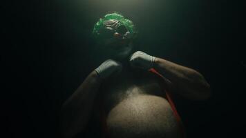 Scary clown posing with arms crossed on dark background video