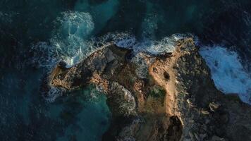 Top view of the powerful turquoise waves crashing against the rocks of Macao into thousands of sparkling splashes in the Dominican Republic at sunset of the warm sun. video