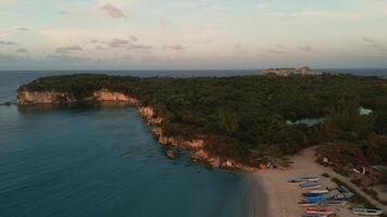 Aerial view of the harbor with colorful boats standing on the ocean shore. A beach near Puerto Plata on the Dominican Island. Sunset on the beach with numerous boats. Travel, nature. video
