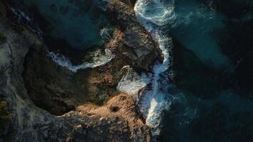 Top view of the powerful turquoise waves crashing against the rocks of Macao into thousands of sparkling splashes in the Dominican Republic at sunset of the warm sun. video