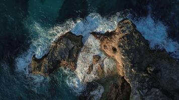 Top view of the powerful turquoise waves crashing against the rocks of Macao into thousands of sparkling splashes in the Dominican Republic at sunset of the warm sun. video