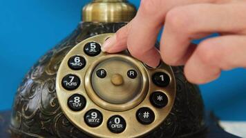 Close-up shot capturing a woman dialing a number on an old rotary phone, showcasing the action in slow motion video