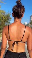 Outdoor Summer Style Back View of a Woman in Colorful Swimwear Accessorizing on the Beach video