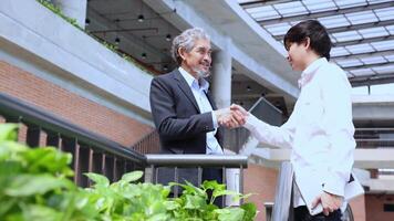 Senior asian executive manager is handshaking with the new trainee employee during probation to pass on knowledge and experience for new generation business inspiration, education and academic video