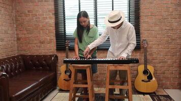Young asian girl is learning how to play keyboard from her teacher in the after school music class for education children skill and talent development video