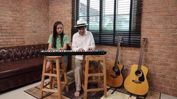 Young asian girl learn how to play keyboard from her teacher in the after school music class for education children skill and talent development concept video