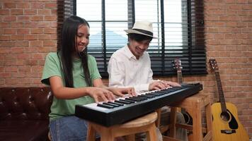 Young asian girl is learning how to play keyboard from her teacher in the after school music class for education children skill and talent development concept video