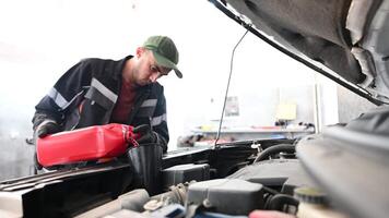 Mechanic Pouring Red Liquid Into Car video
