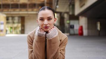 Portrait of young playful woman wearing coat sits on the steps in the city centre of Prague, Europe. High quality 4k footage video