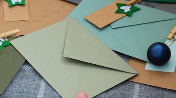 Number on craft envelopes notes with tasks before Christmas holidays. Female making kraft paper for handmade advent calendar Made with your own hands step by step DIY crafts do it yourself video