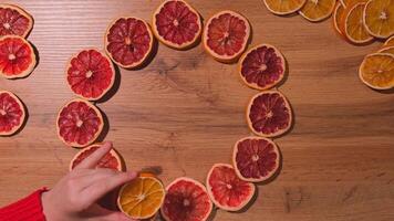 Step 2 DIY process of Woman using hot glue Christmas arrangement with dried oranges and grapefruits. Series of handmade craft instruction. Zero waste eco-friendly winter holiday decoration. New year video