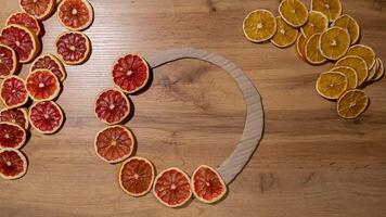 STOP MOTION DIY process of woman making Christmas wreath arrangement with dried oranges and grapefruits. Series of handmade craft instruction. Zero waste eco-friendly winter holiday decoration. New year video