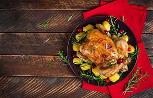 Baked chicken or baked turkey. The Christmas table is served with a turkey. Fried chicken, table setting. Christmas dinner. Flat lay. Top view photo