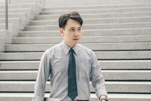 Asian businessman walking to work diligently and briskly in the morning in a big city. A man in a business suit, dressed in a smart suit, runs to work during rush hour in corridors and stairs. photo