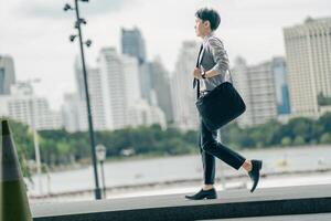 Asian businessman walking to work diligently and briskly in the morning in a big city. A man in a business suit, dressed in a smart suit, runs to work during rush hour in corridors and stairs. photo