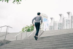 Asian businessman walking to work diligently and briskly in the morning in a big city. A man in a business suit, dressed in a smart suit, runs to work during rush hour in corridors and stairs. photo